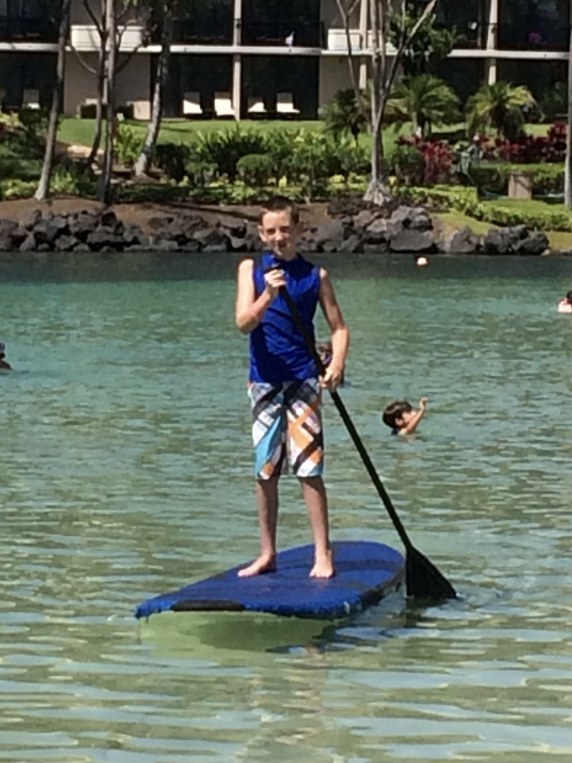 ryan standing on a kyak in a lake